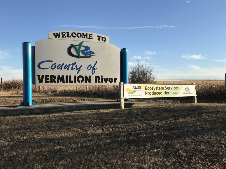 County of Vermilion River Sign with ALUS sign in front blue sky in background